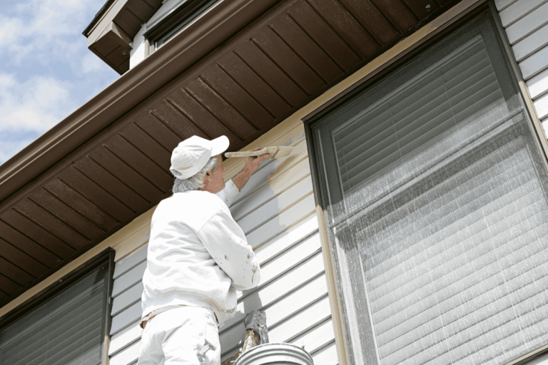Painter working on house exterior